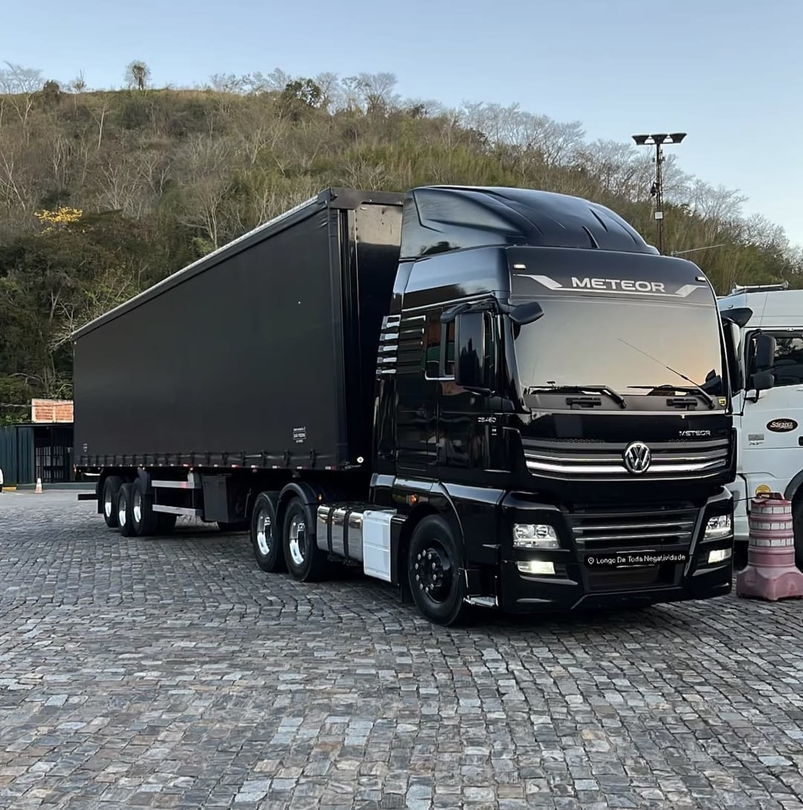VW Meteor preto com carreta sider da Leste Oeste